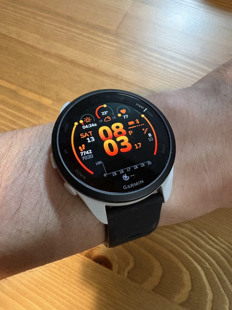 Garmin ForeRunner 165を手首に着用し、時刻・心拍数・歩数などのダッシュボードを表示している様子